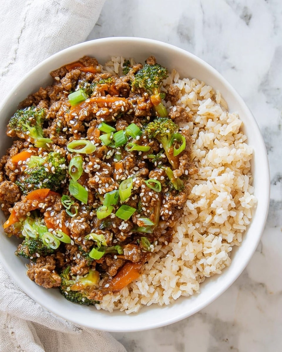 A white bowl filled with two main layers: the bottom layer is light brown cooked rice with a soft texture, and the top layer is a mixed stir-fry of ground meat, small broccoli pieces, thin orange carrot strips, and chopped green onions, all coated in a glossy brown sauce and sprinkled with white sesame seeds. The bowl is placed on a white marbled surface, with part of a white cloth napkin visible on the left edge. Photo taken with an iphone --ar 4:5 --v 7