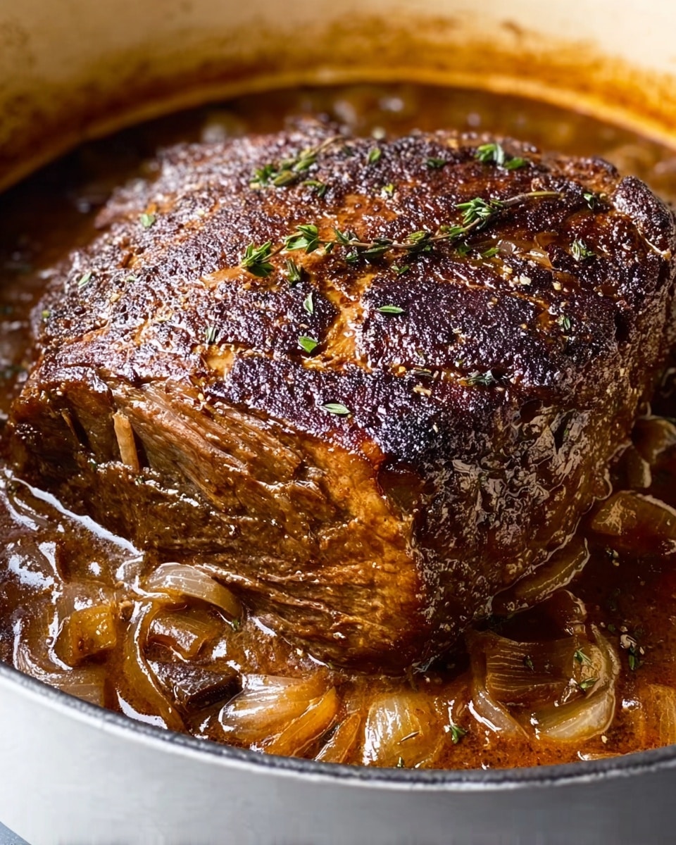 A thick, dark brown piece of cooked meat with a heavily seared, coarse textured crust sits in the center of a large white pot. The pot holds a rich, glossy brown sauce infused with small caramelized onion slices and specks of herbs, which surround the meat. The top surface of the meat has visible slight cracks and a rough texture from the roasting process, while the sides show the meat’s dense, tender fiber. The white pot contrasts with the deep colors of the meat and sauce below. The photo taken with an iphone --ar 4:5 --v 7