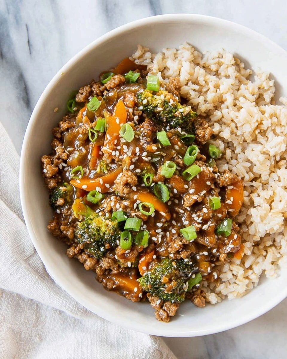 A white bowl filled with two main layers: the bottom layer is light brown cooked rice with a soft, fluffy texture, and the top layer is a mixed stir-fry of ground meat, small broccoli pieces, thin carrot strips, and green chopped scallions. The stir-fry is coated in a glossy brown sauce, sprinkled with white sesame seeds, creating a colorful and textured contrast against the rice. The bowl is placed on a white marbled surface, with a white cloth napkin beside it. Photo taken with an iphone --ar 4:5 --v 7