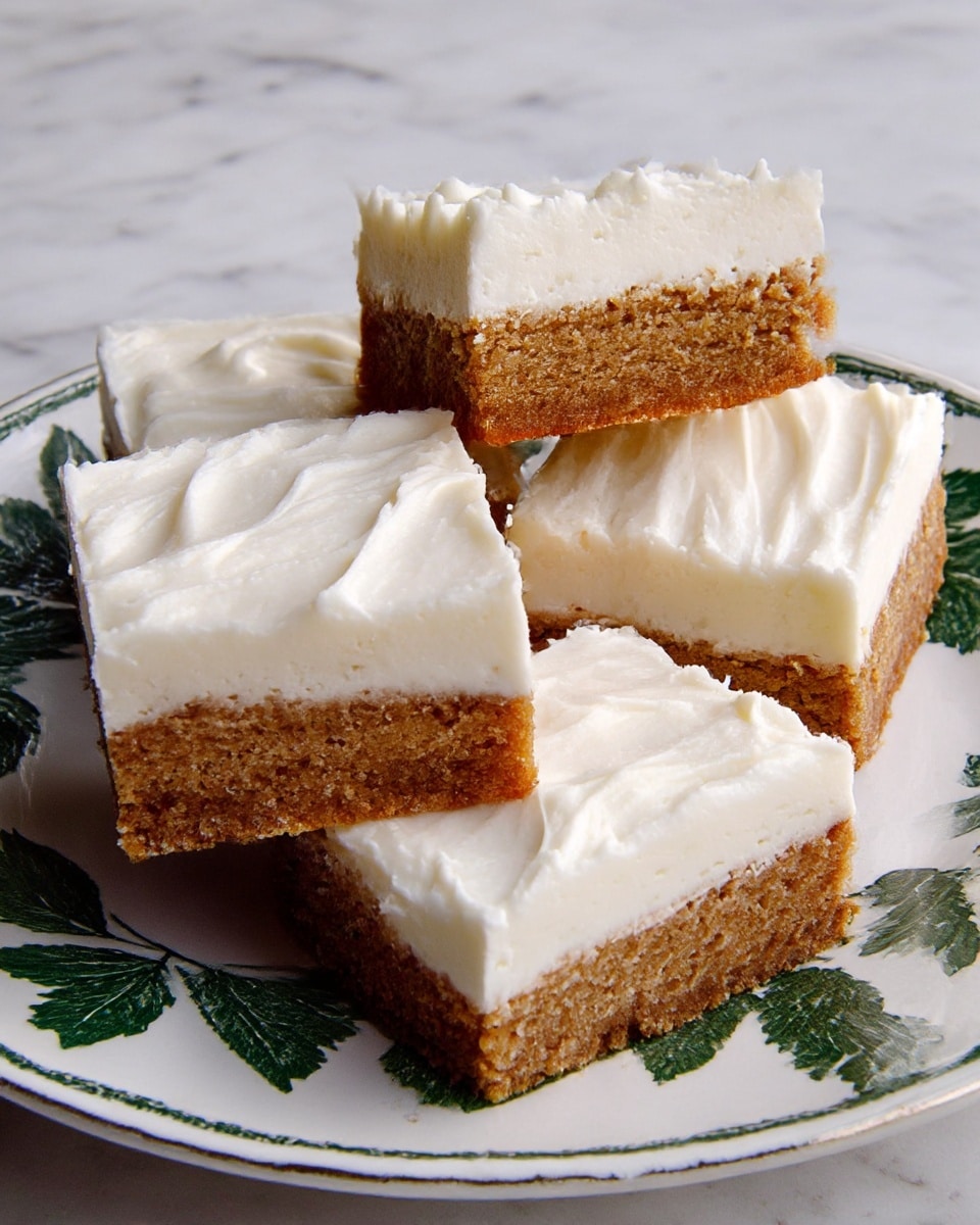 Four square pieces of dessert are shown on a white plate with a floral pattern. Each piece has two layers: the bottom layer is thick, dense, and brown with a soft, crumbly texture, while the top layer is a thick, smooth white frosting with swirled peaks and gentle ridges. One square is stacked on top of two pieces, creating a slight height difference. The background is a white marbled texture. photo taken with an iphone --ar 4:5 --v 7